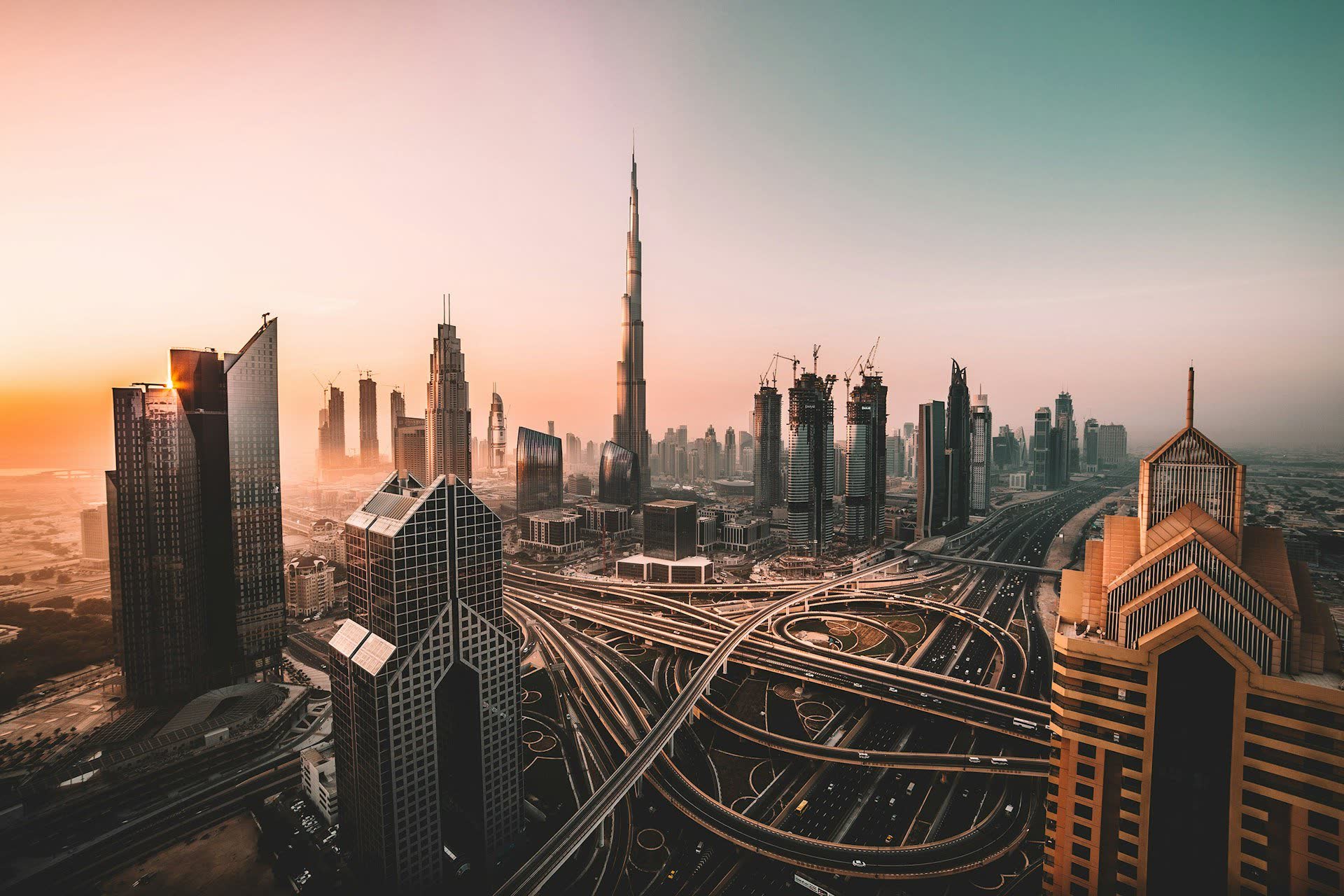 La skyline de Dubaï au coucher du soleil et ses échangeurs autoroutiers. Vivre à Dubaï : notre fiche expatriation.